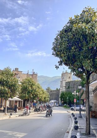 En av stadens större gator. I bakgrunden: en del av stadsmuren och ingången till den befästa delen av staden (kastro).